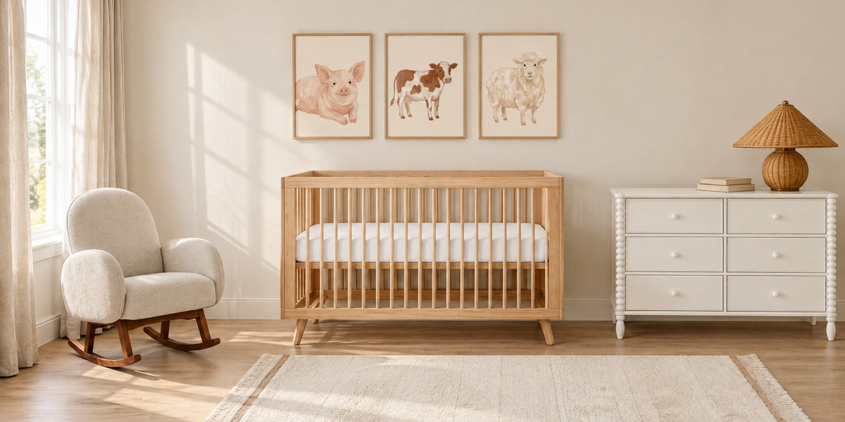 Farm nursery: honey wood crib under three framed pig, cow and sheep prints, with a white dresser, rattan lamp and ivory rocker