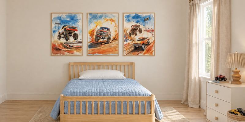 Monster truck bedroom: three stadium monster truck prints above a pale pine bed with a dusty blue quilt