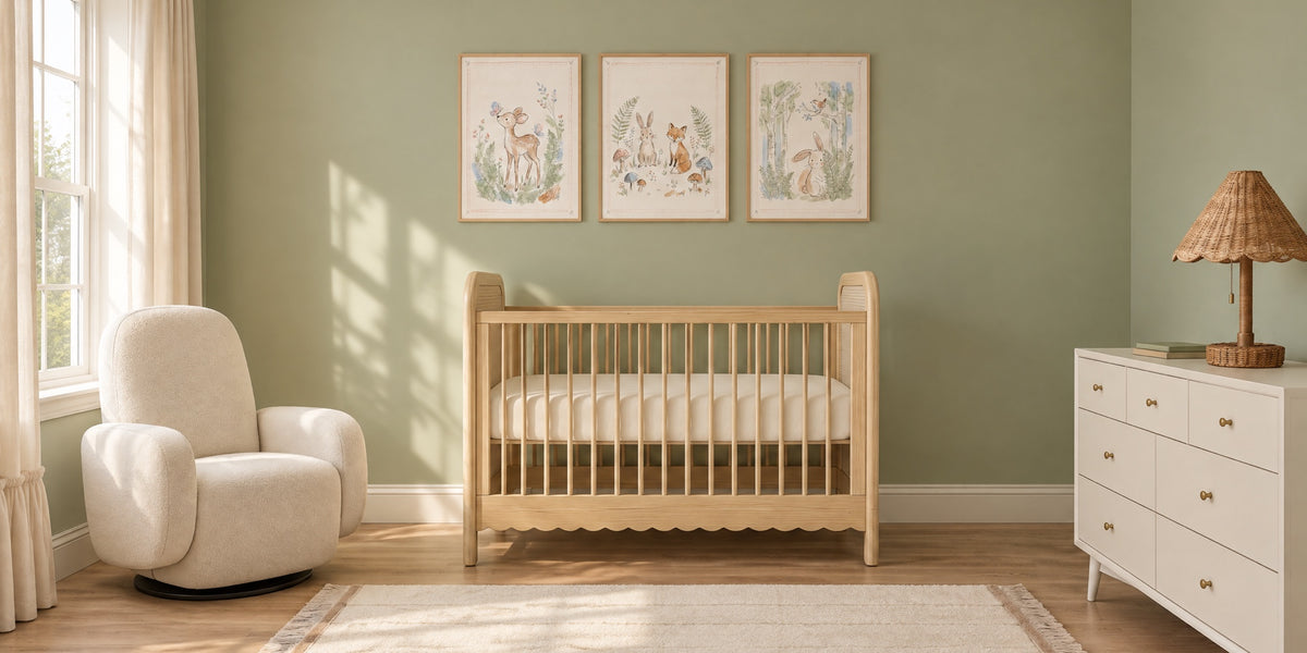 Sage green nursery: sage walls, a pale wood crib under three framed woodland animal prints, a cream glider and a white dresser