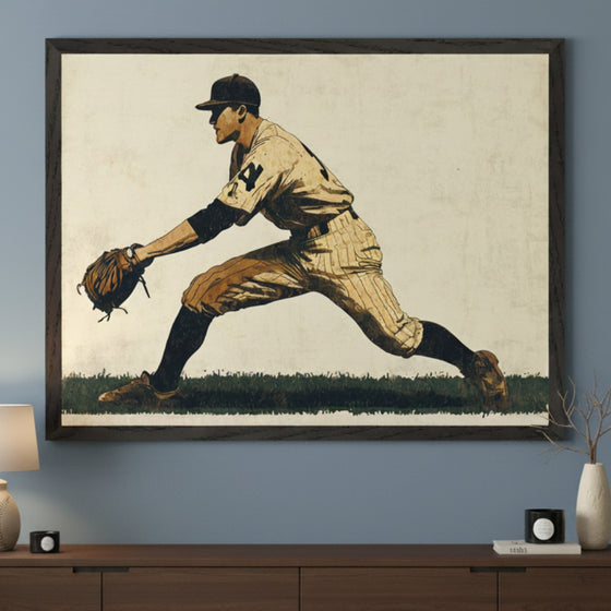 Modern room with a dark wood dresser. A large framed print of a vintage-style baseball player in a pitching stance, wearing a uniform with "24" on the back, hangs centered above the dresser. The artwork features a light background and dark green grass.