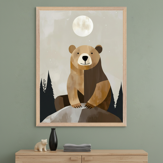 Framed wall art of a stylized brown bear sitting on a rock under a full moon, with a background of dark pine trees and a muted night sky. Displayed above a wooden dresser holding a small bear figurine, a black vase, and neatly folded linens.