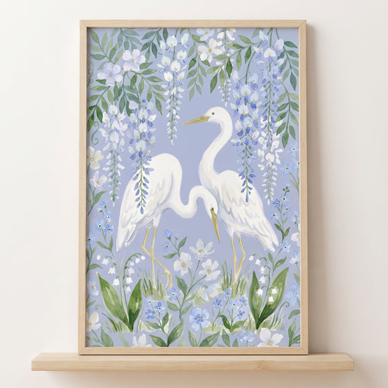 Two white egrets stand among hanging vines and blooms in this blue wisteria white egret bird wall art.