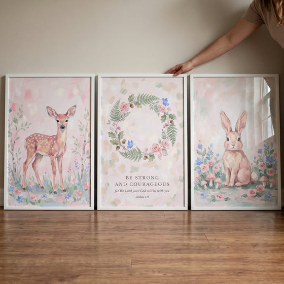 Blush petal woodland floral wall art set of 3 features a deer, a rabbit, and a wreath with scripture in white frames.
