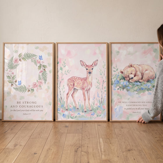 Blush pink floral scripture bible wall art set of 3 with a wreath, a spotted fawn, and a sleeping bear cub on wood floor.
