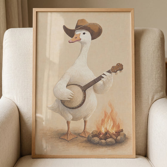 Framed campfire banjo playing goose wall art shows a white goose in a cowboy hat strumming a banjo beside a fire.