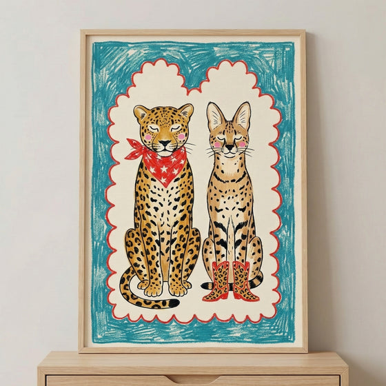 Whimsical illustration of a serval and a leopard sitting side by side, both with pink cheeks and closed eyes. The leopard wears a red star-patterned bandana, and the serval sports red cowboy boots. The image is framed with bold crayon-like blue and red borders, giving it a playful, childlike charm.