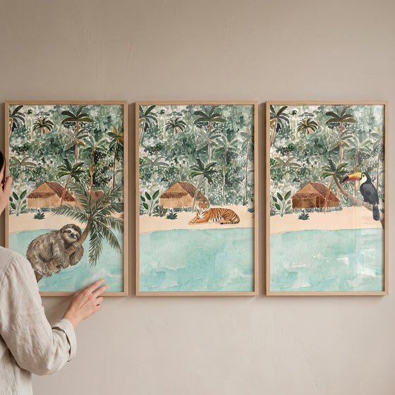Coastal beach jungle animals wall art set of 3 featuring a sloth, tiger, and toucan in tropical landscapes.