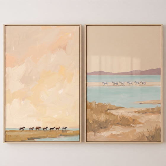 coastal marshland wild horses wall art set of 2 in muted peach and blue tones with horses walking across a sandy shore.