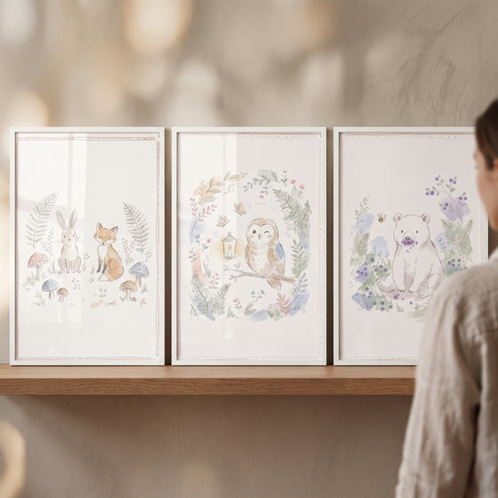Three framed cottagecore meadow woodland animal wall art set of 3 illustrations with a rabbit, fox, owl, and bear on a shelf.