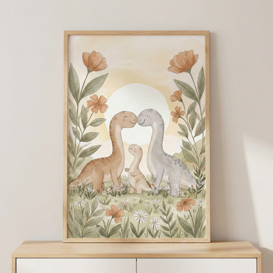 A vertically framed watercolor-style illustration features three long-necked dinosaurs in soft, pastel tones. A larger earthy brown dinosaur and a grey one lean their heads toward each other over a smaller brown dinosaur, creating a sweet family scene. They stand in a field of grass and wildflowers under a large, pale sun. Tall, stylized orange floral stalks frame the scene on either side. The framed artwork sits on a light wooden cabinet against a plain, neutral wall.