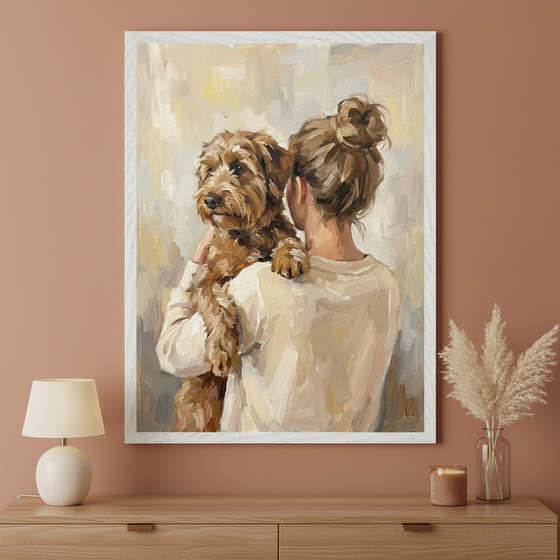 Modern room with a wooden dresser. Above it, a framed oil painting depicts a woman from behind holding a brown dog. The impressionistic style features thick brushstrokes and a light, abstract background. A lamp, candle, and pampas grass sit on the dresser.