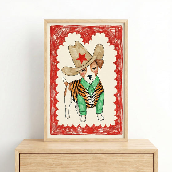 A framed illustration of a dog wearing a large cowboy hat with a red star, a green shirt, and a tiger-striped vest, set against a cream background with a red scalloped border. The playful western-themed art gives the dog a charming cowboy persona.