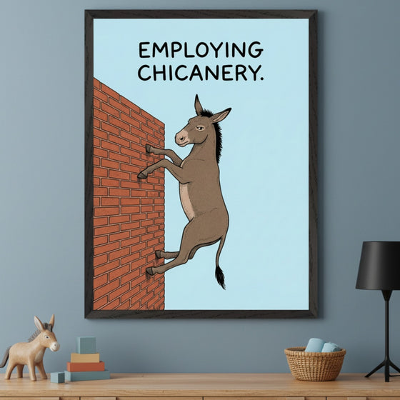 Modern room with a wooden dresser. Above it, a framed print shows a cartoon donkey climbing a brick wall on a light blue background. Text reads "EMPLOYING CHICANERY." A wooden donkey figurine and colorful blocks are on the dresser.