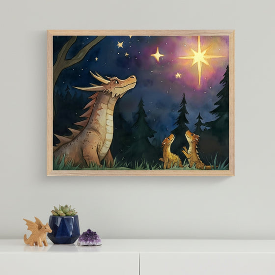 Modern room with a white dresser. A framed watercolor-style art print hangs above, depicting a large brown dragon and two small tan dragons looking up at a bright star in a dark forest at night. A small succulent, a dragon figurine, and an amethyst cluster are on the dresser.