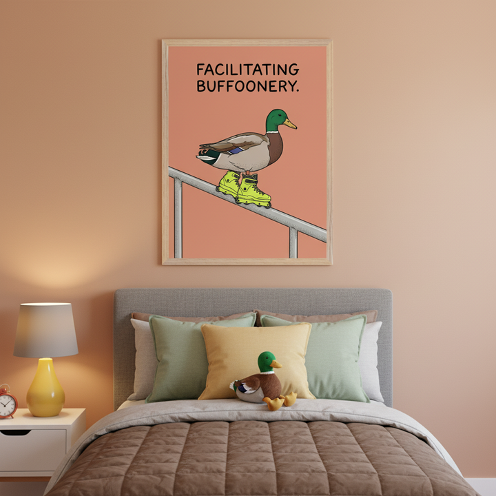 Bedroom with a bed, nightstand, and lamp. A framed illustration of a mallard duck wearing bright green rollerblades on a railing, with text "FACILITATING BUFFOONERY", hangs above the bed.