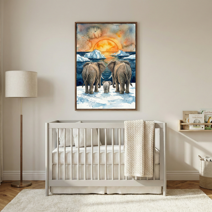 A serene nursery featuring a light gray wooden crib with neutral bedding. Above the crib, a large framed artwork depicts two large elephants and a small calf standing on a snowy shore, looking out at a calm sea with icebergs under a vibrant orange and yellow sunset. To the left is a tall floor lamp with a beige cylindrical shade, and to the right is a small wooden wall shelf holding books. The room has light wood floors and a plush cream-colored rug.