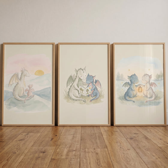 Fairytale storybook baby dragons wall art set of 3 showing watercolor dragons reading, holding a lantern, and at sunset.