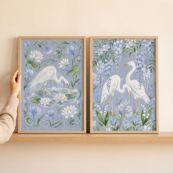 Grandmillennial floral white heron bird wall art set of 2 on a shelf, featuring herons among lilies and blue wisteria.