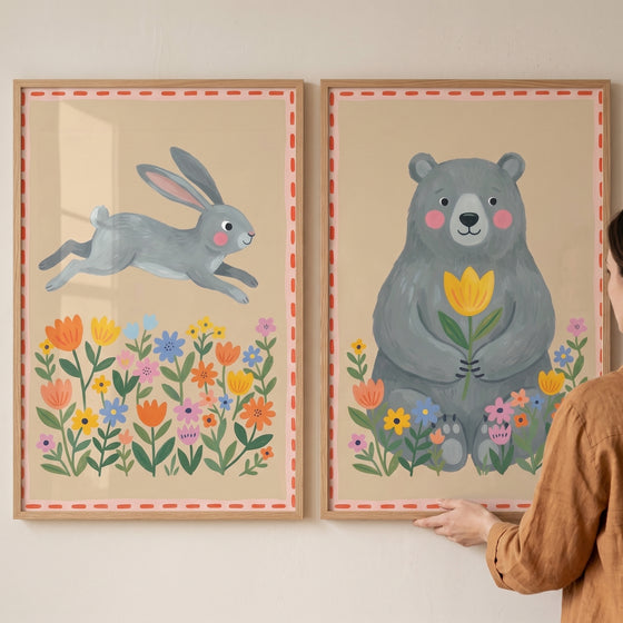 Grey whimsical forest animals artwork set of 2 featuring a leaping rabbit and a sitting bear among colorful flowers.
