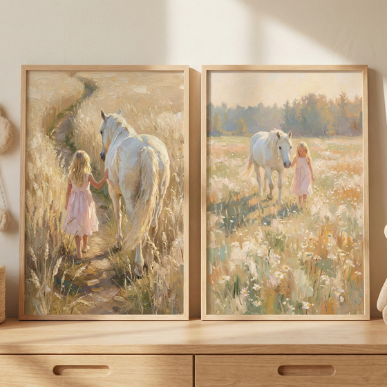 Two framed art pieces are displayed on a wooden surface against a neutral wall. The left image shows a young girl with blonde hair wearing a pink dress, walking away down a dirt path through tall grass alongside a white horse. The right image depicts a young girl in a pink dress walking toward the viewer through a meadow of wildflowers with a white horse. Both artworks have a textured, impressionistic style and are set in light wood frames.