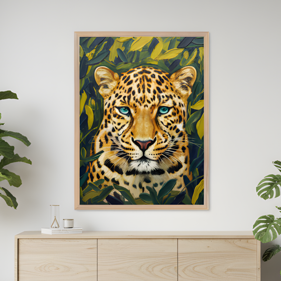 Framed artwork of a leopard with piercing blue eyes, surrounded by lush green and yellow foliage, hangs on a white wall above a minimalist wooden sideboard. The vivid colors and lifelike detail of the leopard contrast with the clean, modern decor and nearby leafy plants.