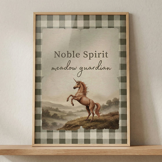 Framed print with a gingham border features a rearing unicorn on a grassy hill with soft mountains in the background. Text reads "Noble Spirit" and "meadow guardian" above the illustration, giving the artwork a whimsical and storybook feel for a nursery space.