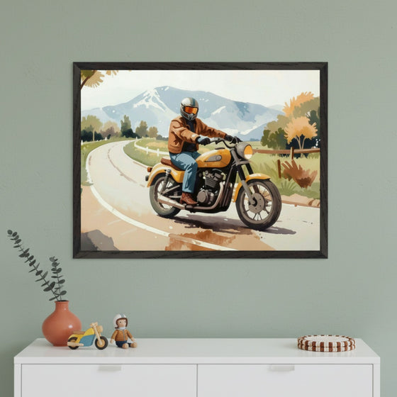 Modern room with a sage green wall and a white dresser. A framed watercolor-style painting of a person riding a yellow motorcycle on a road with mountains in the background hangs above the dresser.