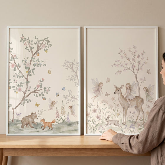 Muted pink blossom fairies wall art set of 2 features watercolor woodland animals and forest fairies in white frames.