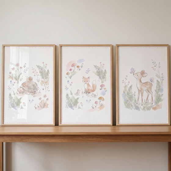 Organic garden woodland animal wall art set of 3 watercolor illustrations of a turtle, fox, and deer in light wood frames.