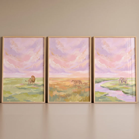 Pastel sunset safari animals wall art set of 3 with a lion, lioness, and elephant under pink skies in wooden frames.