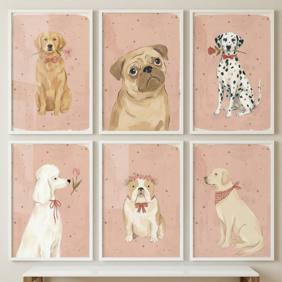 Six framed dog illustrations are displayed in a three-by-two grid on a neutral wall above a rustic wooden shelf. Each portrait features a dog against a textured pink backdrop adorned with small, scattered brown dots and a soft white border.
