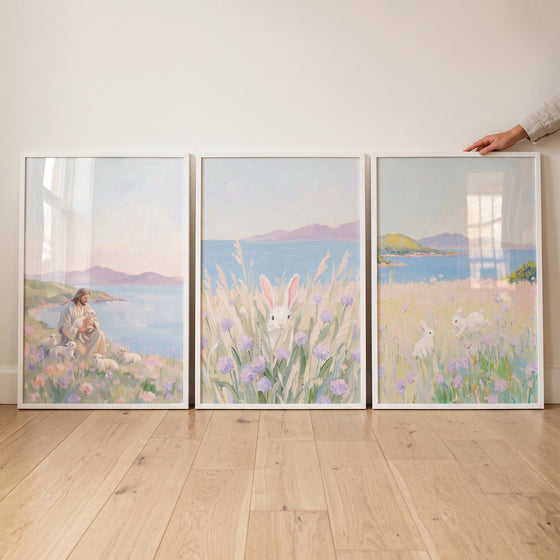 Jesus with lambs and rabbits in a serene lavender meadow coastal wall art set of 3 framed against a white wall.