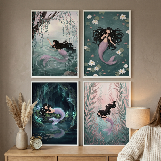 Four framed mermaid illustrations displayed on a wooden dresser showing soft underwater scenes with flowing dark hair lily pads caves and sea plants in muted pastel tones. A vase with dried grasses and a small clock sit beside the prints while part of a person in a cozy sweater is visible creating a warm styled home decor setting.