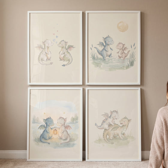 Serene pastel baby dragons wall art set of 4 features whimsical creatures in white frames on a neutral wall.