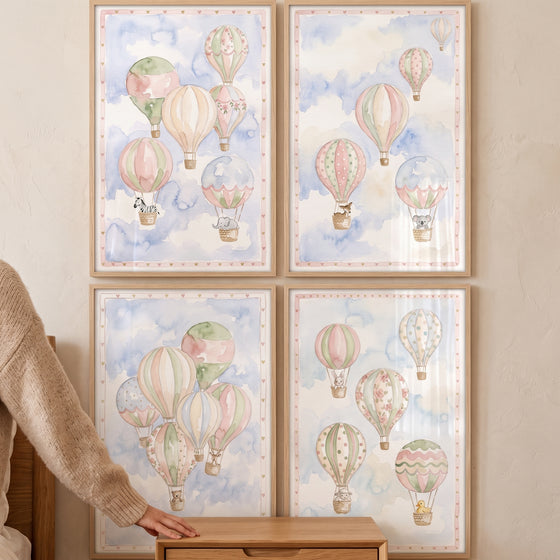 Shabby chic hot air balloon print set of 4 with cute animals in pastel watercolor framed on a wall.