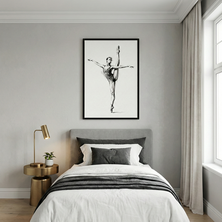 A minimalist bedroom featuring a single bed with white bedding and layered gray pillows. Above the headboard, a large, black-framed artwork displays a black and white sketch of a graceful ballerina in mid-pose. A sleek, gold-toned side table sits to the left, holding a contemporary gold lamp and a small plant. To the right, a window is framed by long, light-colored curtains, letting natural light onto the pale wood floor and light gray walls.