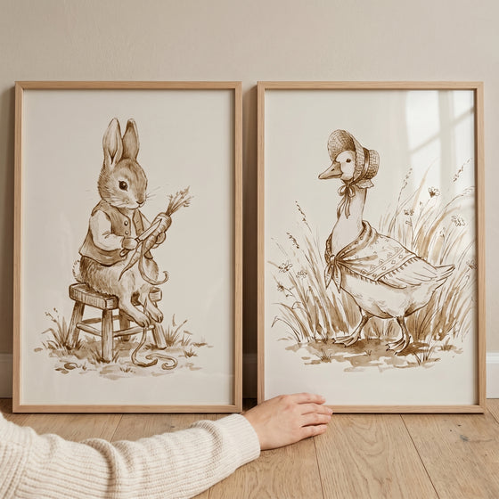 Framed sketched vintage garden animal wall art set of 2 showing a rabbit peeling a carrot and a goose in a bonnet.