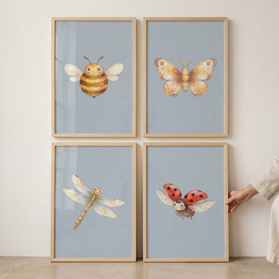 Smiling blue watercolor insect wall art set of 4 with a bee, butterfly, dragonfly, and ladybug in wood frames.