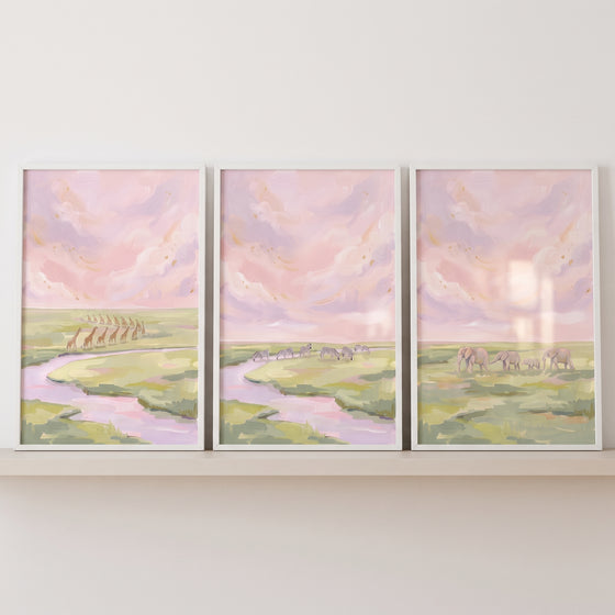Soft cloudy safari animals wall art set of 3 features pastel giraffes, zebras, and elephants in a grassy landscape.