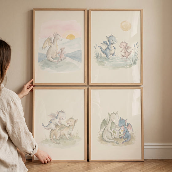 Soft pastel baby dragon wall art set of 4 in light wood frames held against a neutral wall.