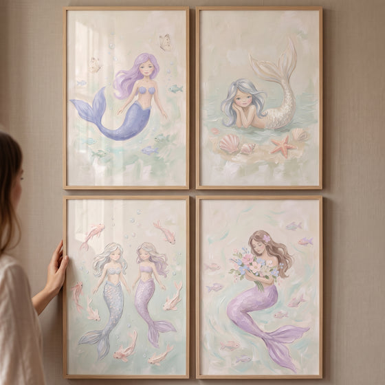 Soft pastel ocean mermaid wall art set of 4 in wooden frames displayed on a wall as a person adjusts one frame.