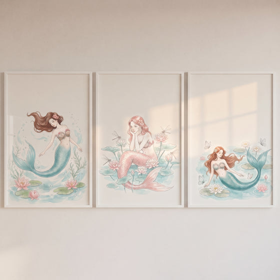 Sophisticated pastel watercolor mermaid wall art set of 3 with pink and teal mermaids among lily pads.