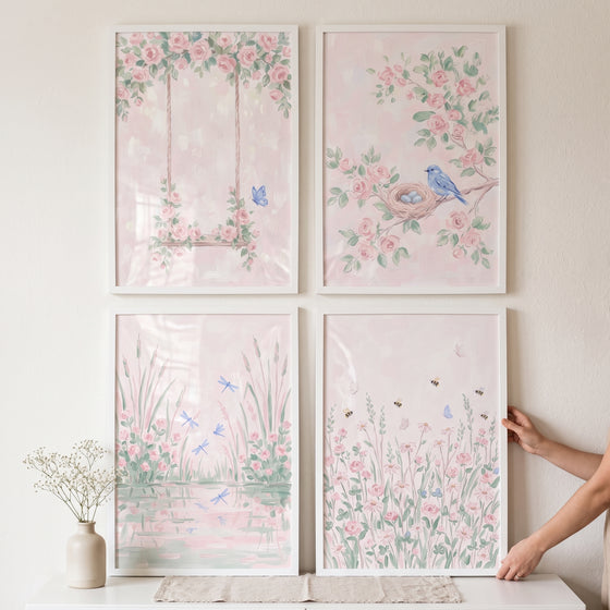 Storybook pink garden artwork set of 4 featuring floral scenes with a swing, bird, and insects in white frames on a wall.