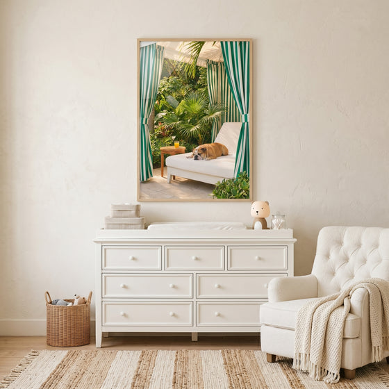 Striped cabana sleeping bulldog wall art on a white dresser shows a dog on a lounge chair near a glass of orange juice.