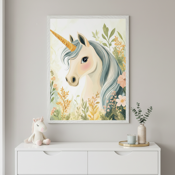Whimsical unicorn with a golden horn and flowing silver-blue mane stands surrounded by soft pastel leaves and flowers. The artwork is displayed in a black frame on a tabletop next to wrapped gifts and decorative tape.