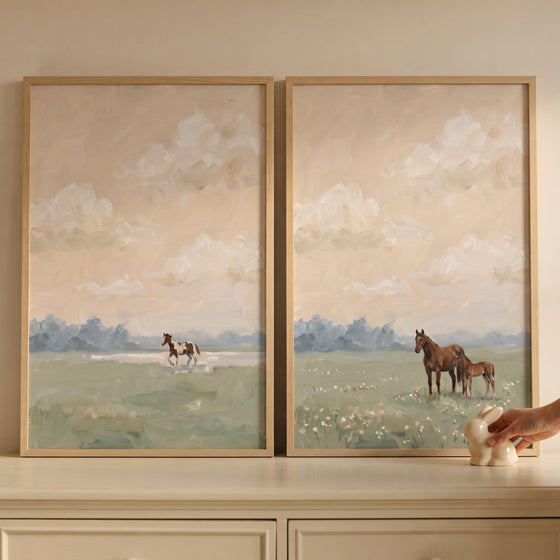 Vintage equestrian landscape horse wall art set of 2 depicts horses in a field under a cloudy sky on a light dresser.