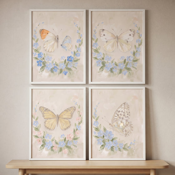 Vintage wildflower wreath butterfly wall art set of 4 in white frames on a beige wall above a light wood table.