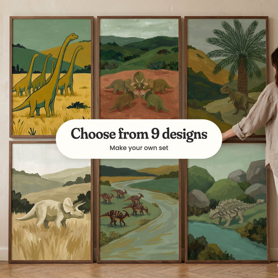 Six dinosaur prints in dark wood frames on a herringbone floor: long-necks in golden grass, a circle of triceratops, a T. rex under a palm, a pale triceratops, crested dinosaurs by a river and an armored dinosaur, with a label reading Choose from 9 designs, Make your own set