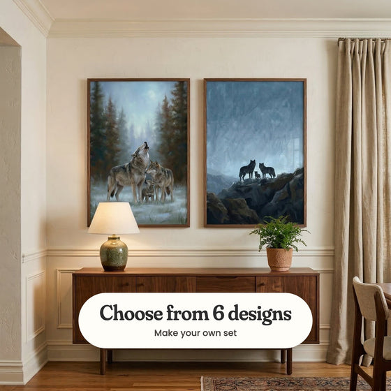 Cream panelled room with two wolf prints in dark wood frames above a walnut sideboard with a green ceramic lamp and a fern in a pot, beside a linen curtain, a wooden chair and a patterned rug: Midnight Pack Song and Mountain Wolf Family, with a label reading Choose from 6 designs, Make your own set
