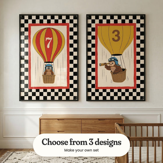 Pale grey panelled room with two owl balloon prints in black frames above a wood dresser, beside a wood crib and a patterned rug: Aviator Owl and Wise Skyward Watcher, with a label reading Choose from 3 designs, Make your own set